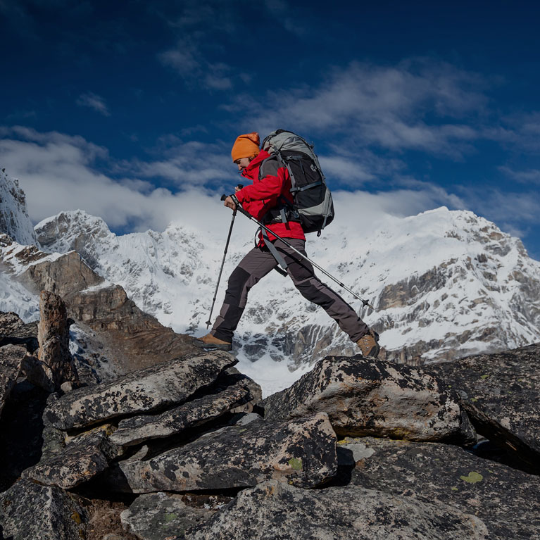 Experienced Hiker Crossing Difficult Terrain Amidst Snow-Capped Peaks | Outdoor Adventure Image