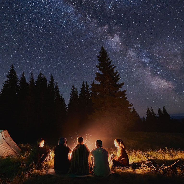 Friends Sharing Stories Around Campfire Under Milky Way | Outdoor Adventure Image